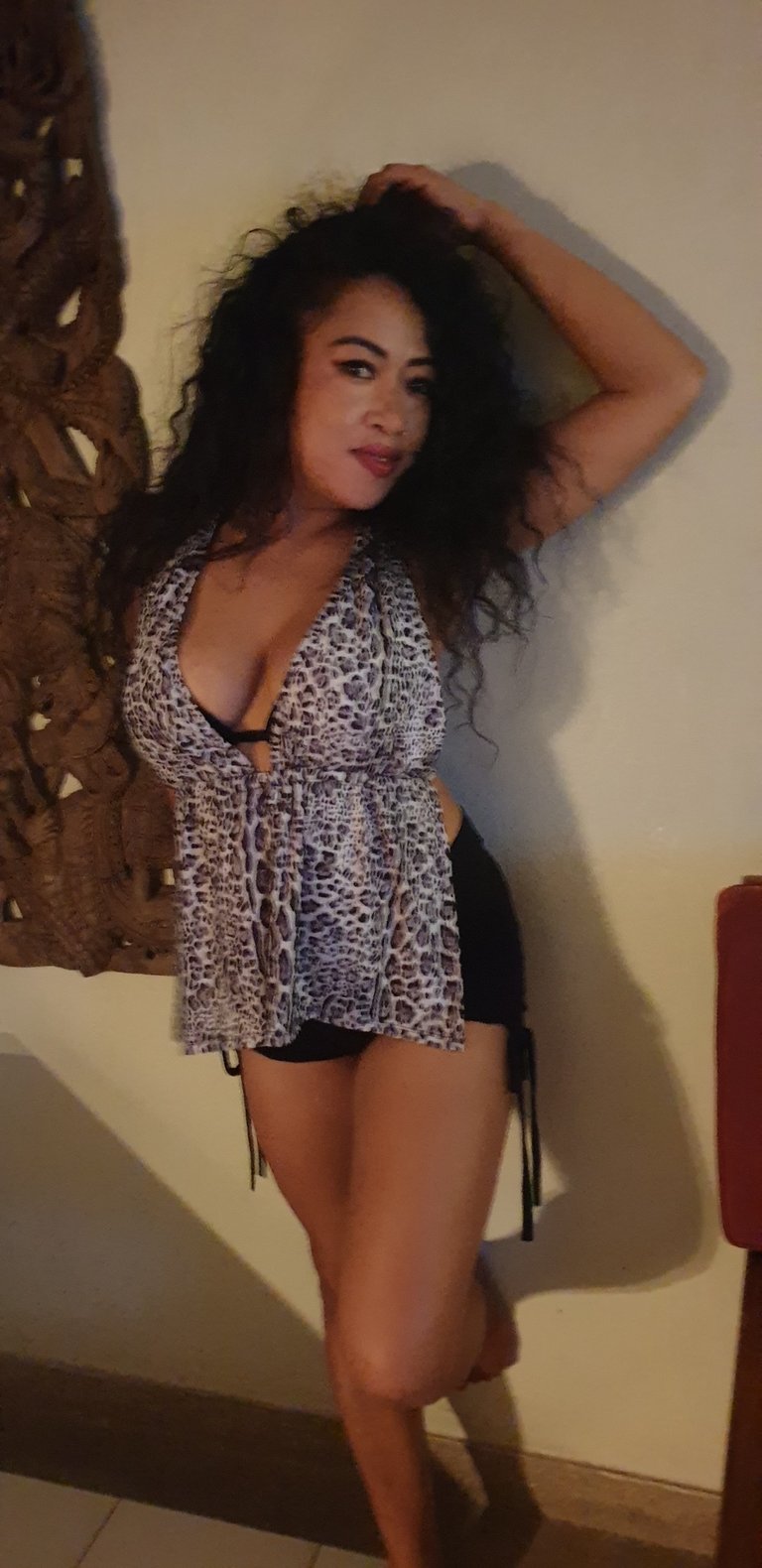 therapist for outcall massage service posed with arm raised and hand touching head