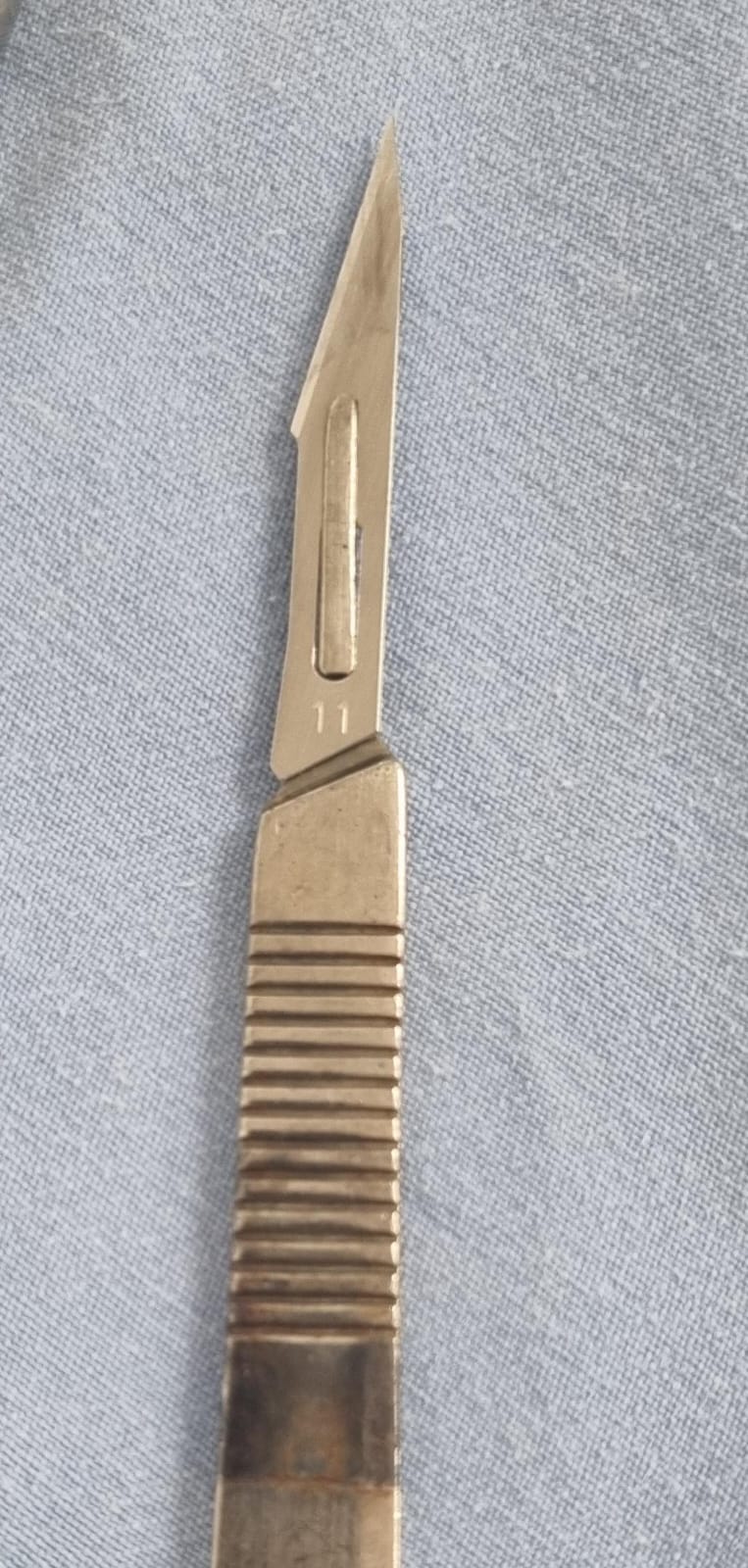 a knife and a knife blade on a blue cloth