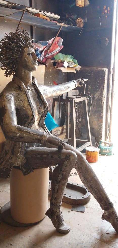 Sculpture métallique réalisée à la main représentant une femme assise aux cheveux hérissés, dans l'a