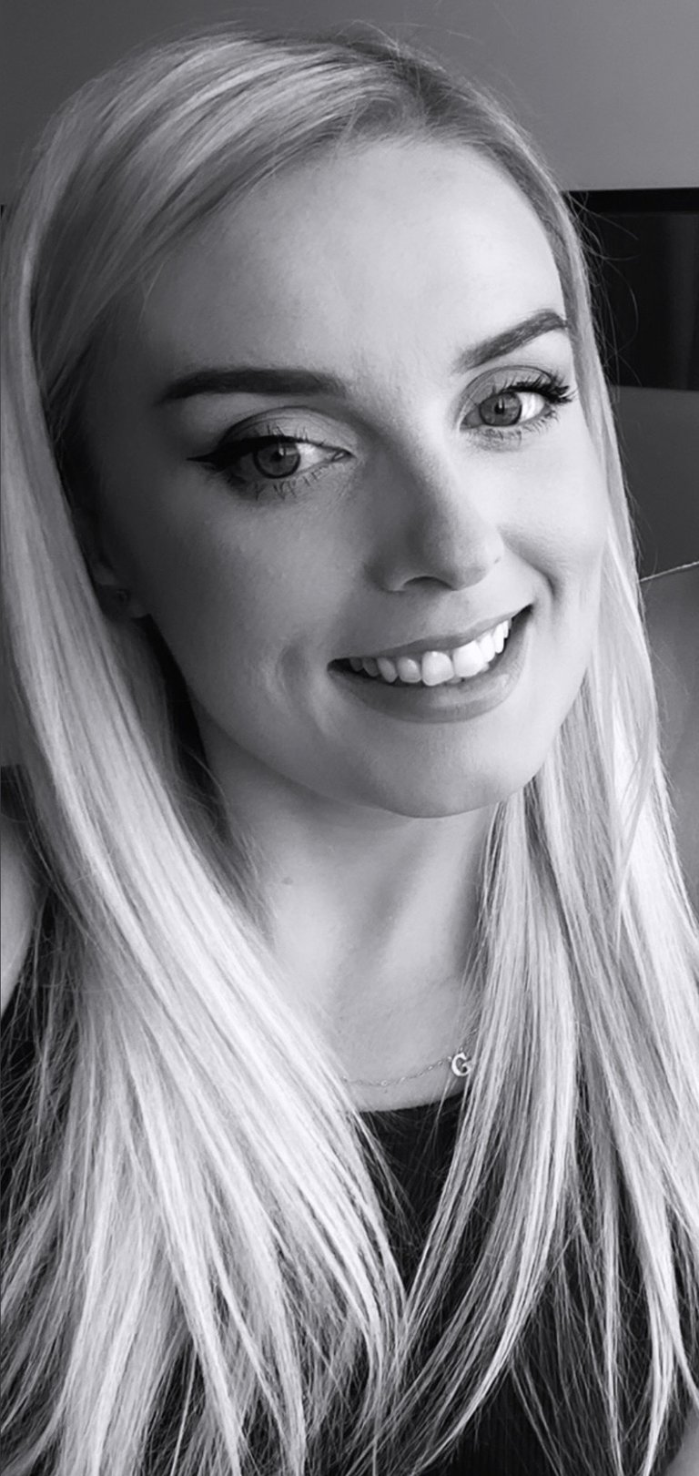 a woman with blonde hair and a black top