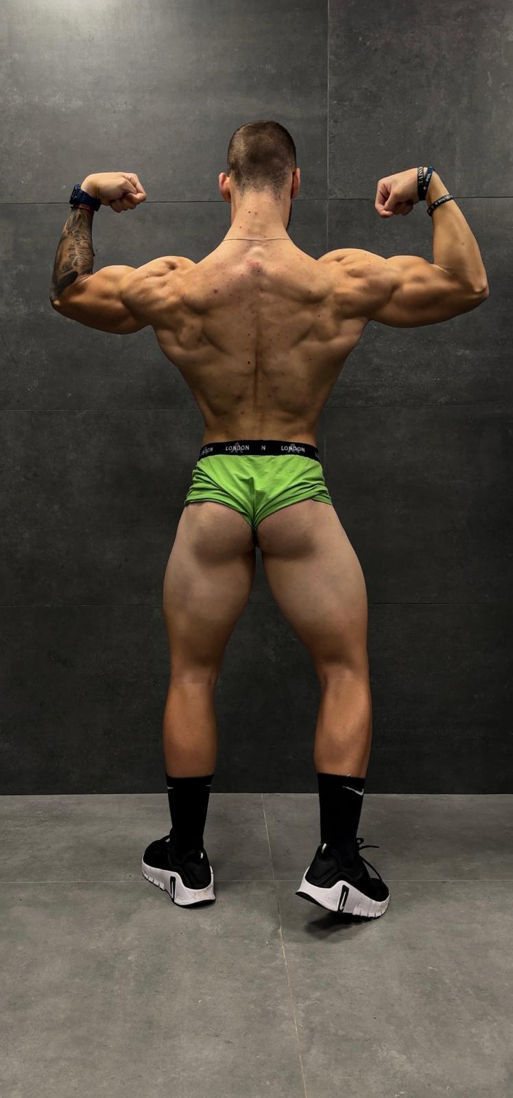 a man in a green underwearsuit with a muscular body