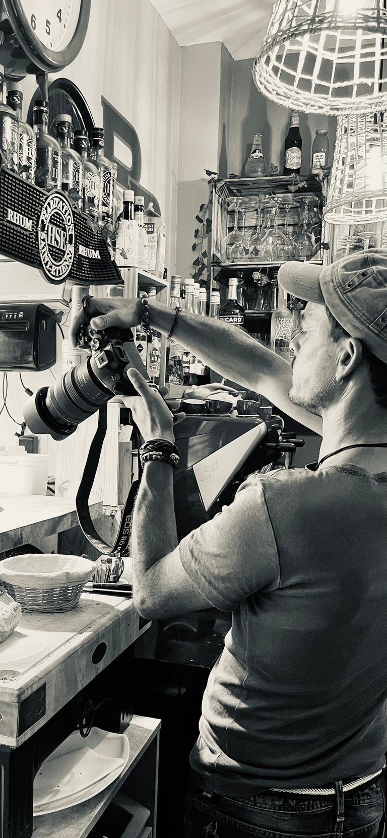 Jeune homme qui prend une photo d'un plat dans un restaurant à La Baule