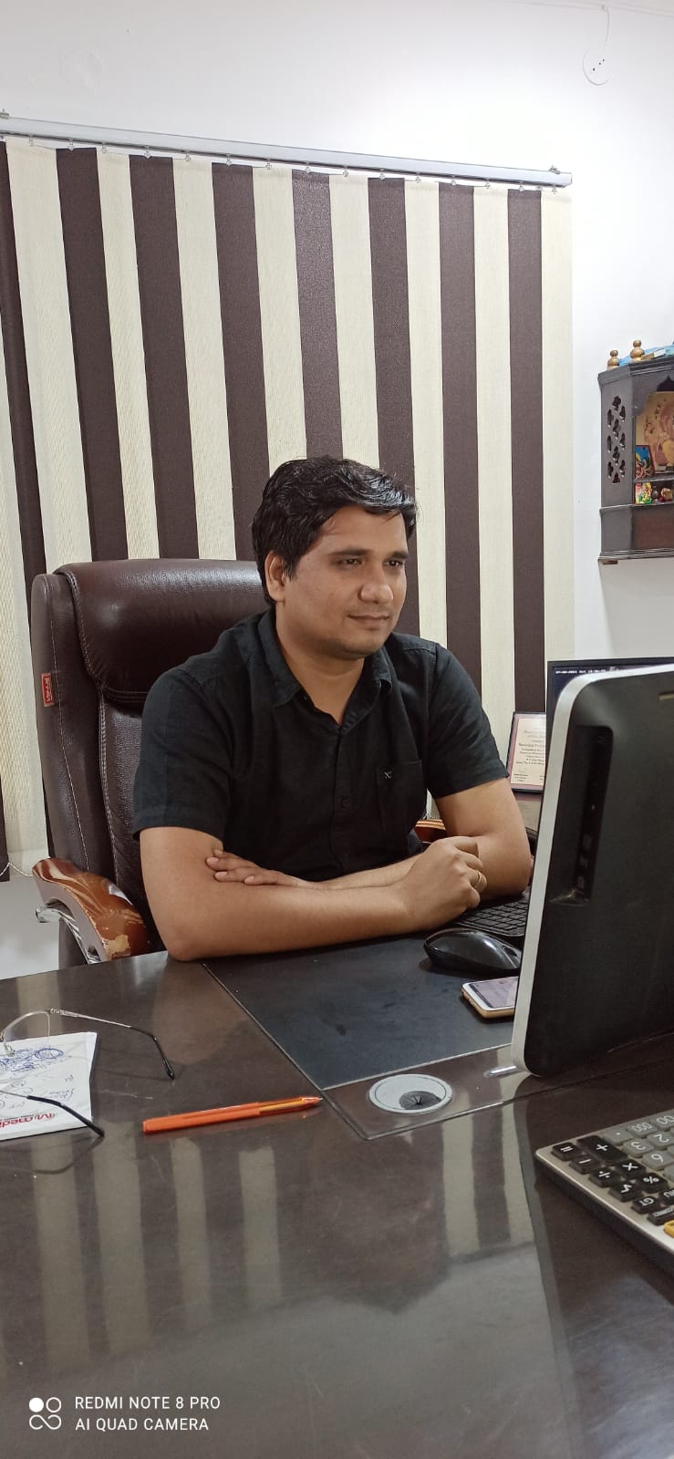 a man sitting at a desk with a laptop computer