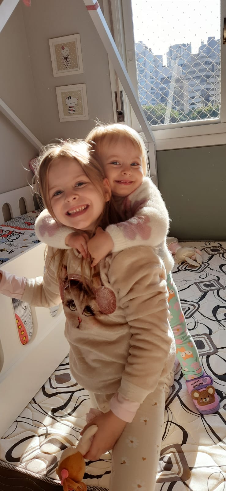 two young children in a bed with a teddy bear