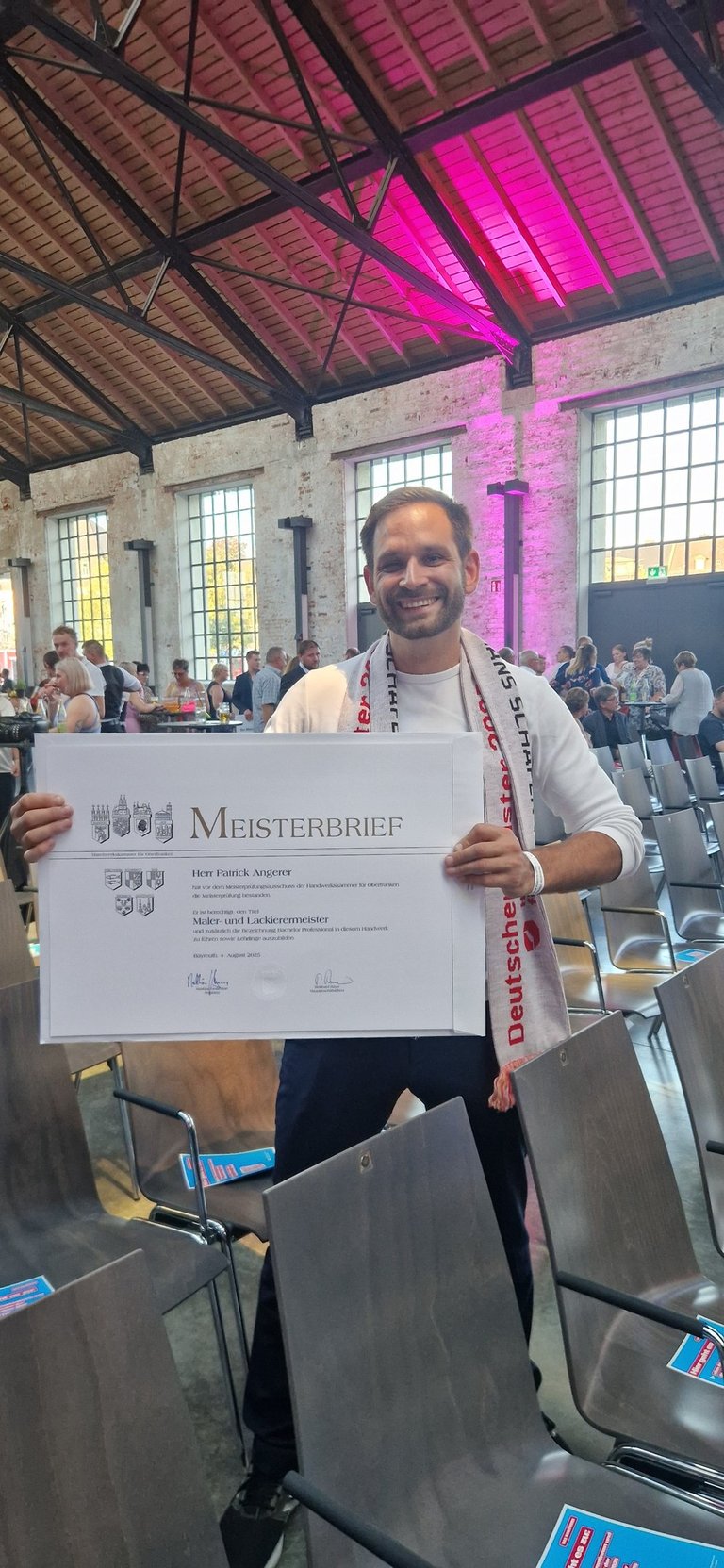 Patrick Angerer der seinen Meisterbrief in der Hand hält