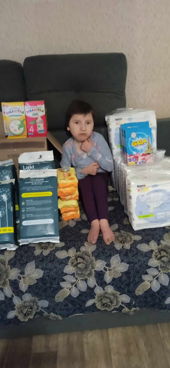 дівчинка сидить на дивані з великою кількістю підгузників