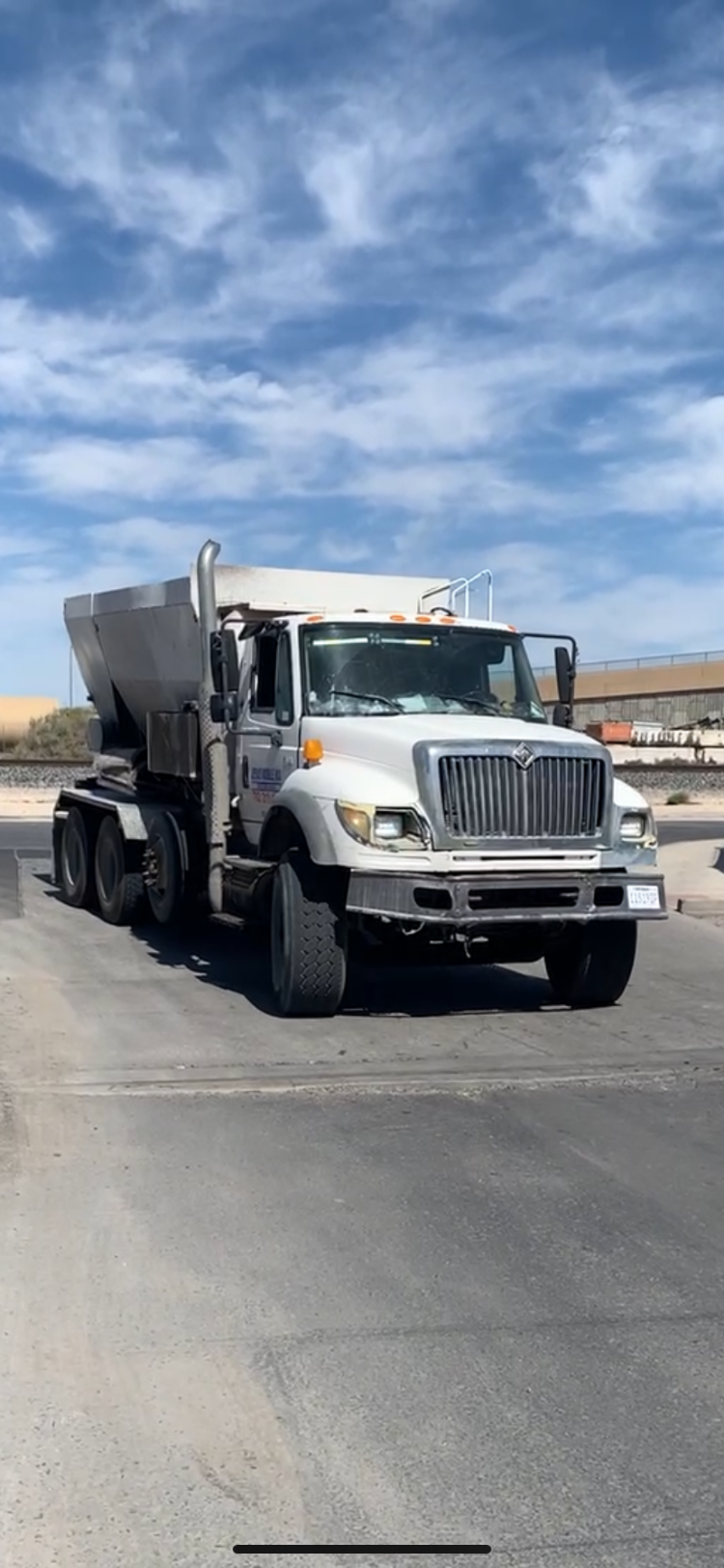 a dump truck with a cement mixer in the back ground