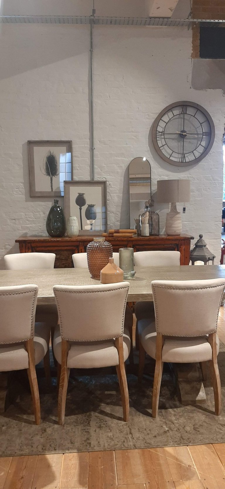 a dining room table with a clock on the wall