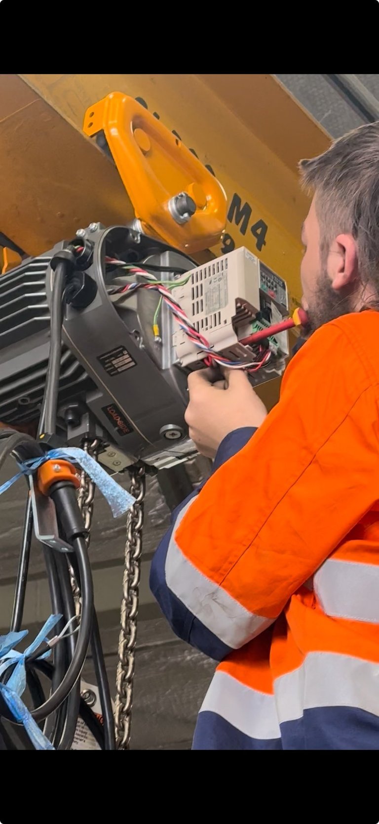 crane technician inspecting and adjusting electrical components