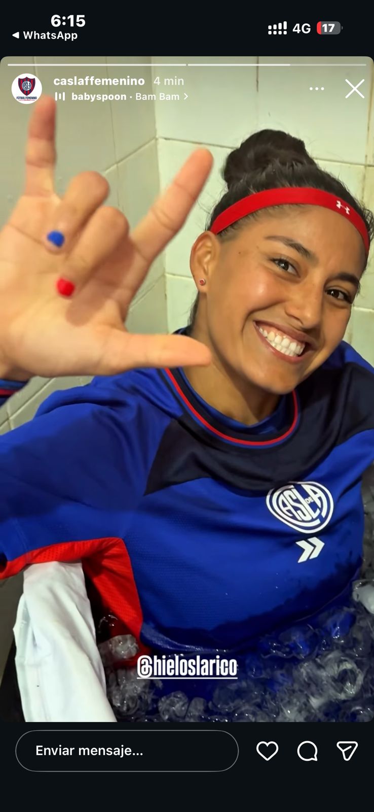 Smiling soccer player in a blue San Lorenzo jersey taking an ice bath recovery session.
