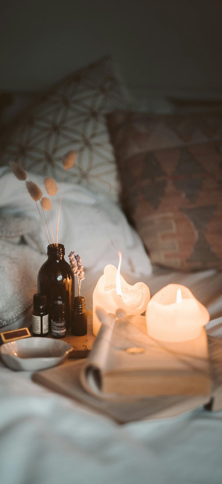 Close-up of tea lights and fragrance oils used to create layered winter scent styling