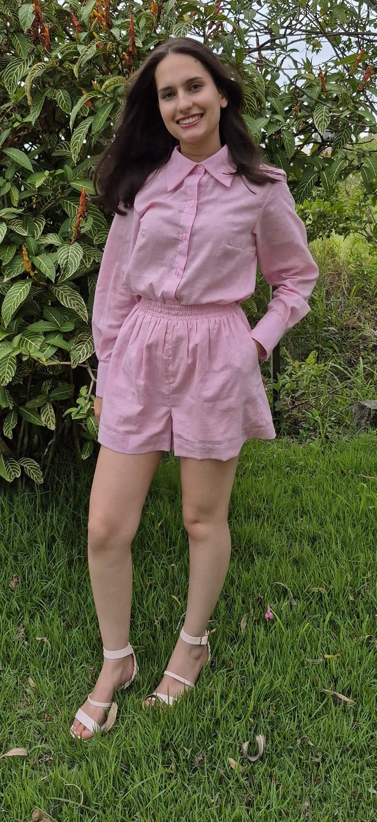 Mulher usando um conjunto rosa claro de camisa e shorts