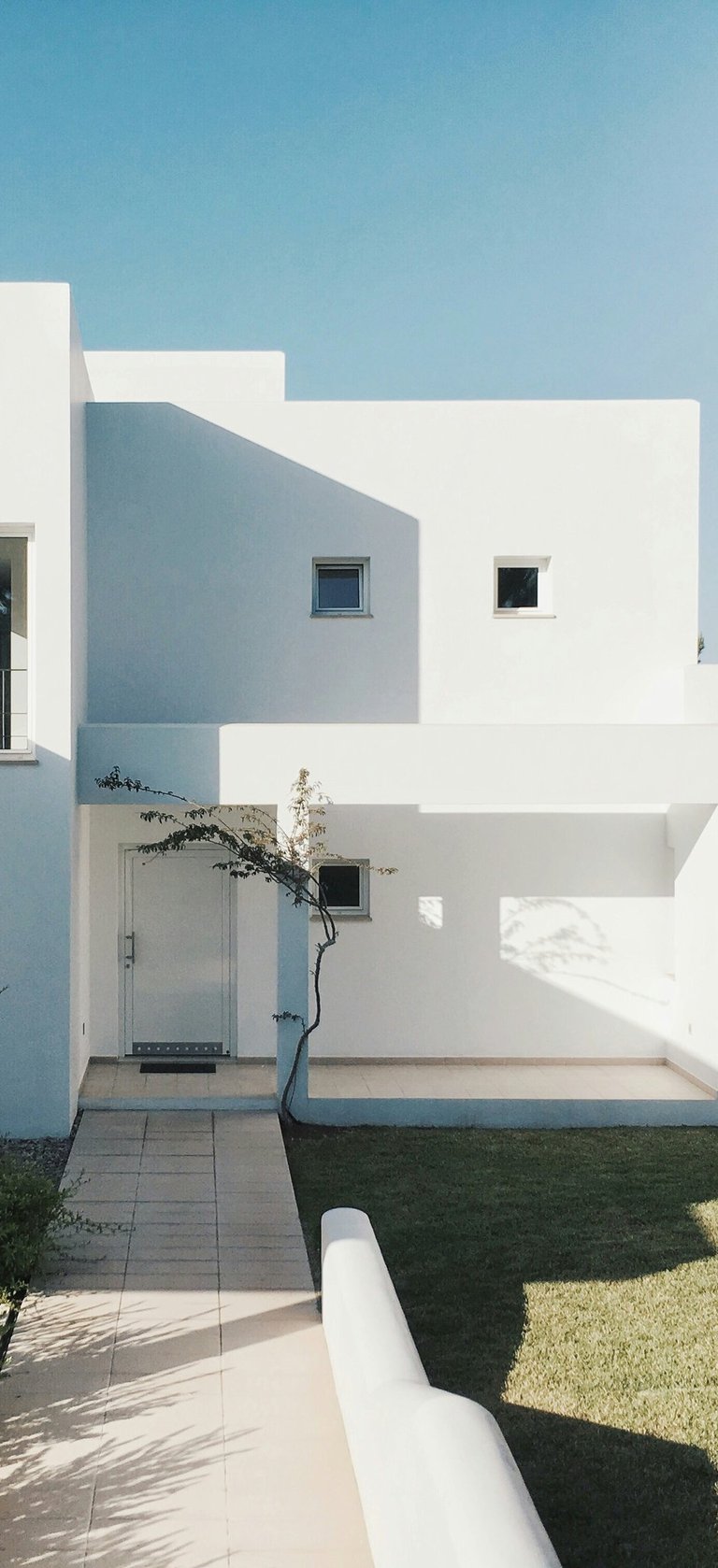 Minimalist white cubic residence with clean geometry and landscaped garden