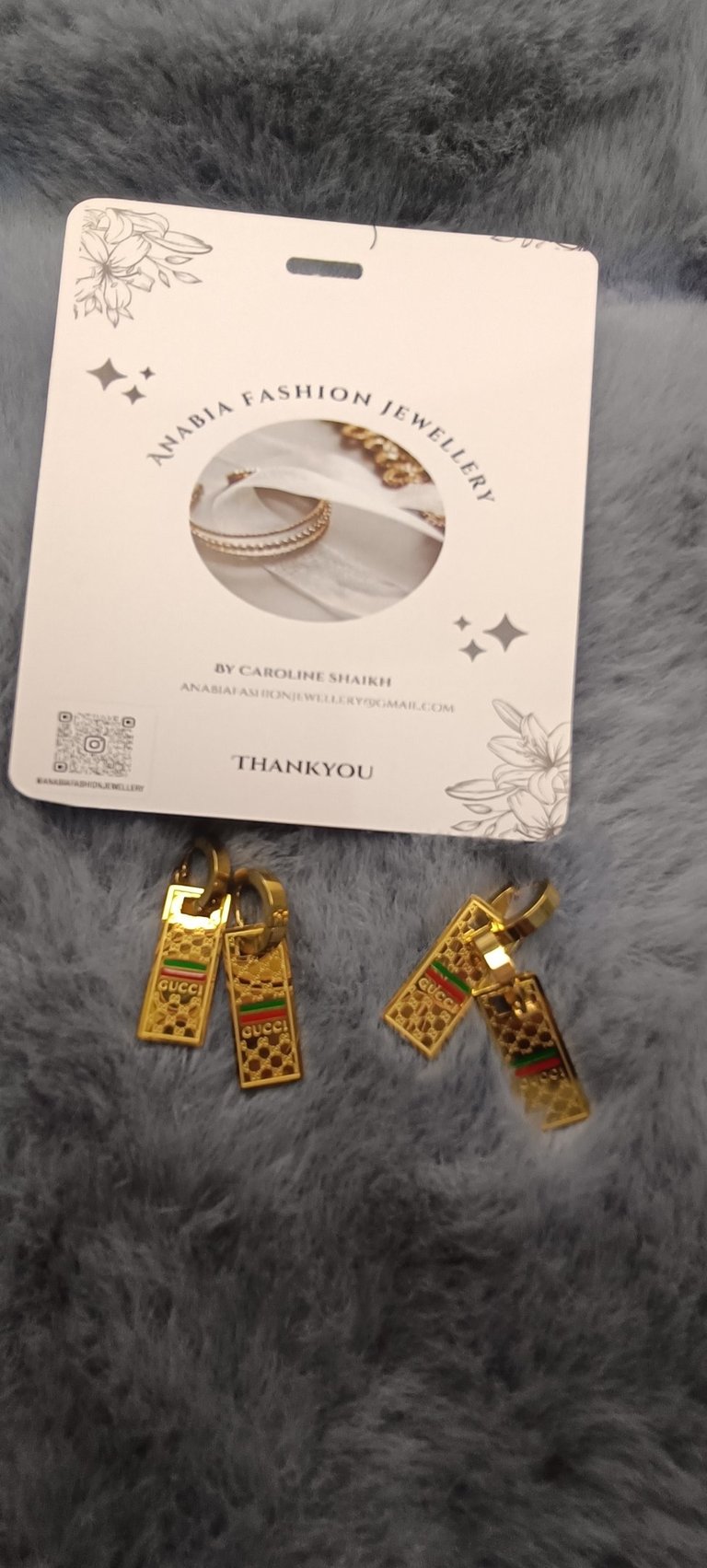 a pair of earrings with gold and silver