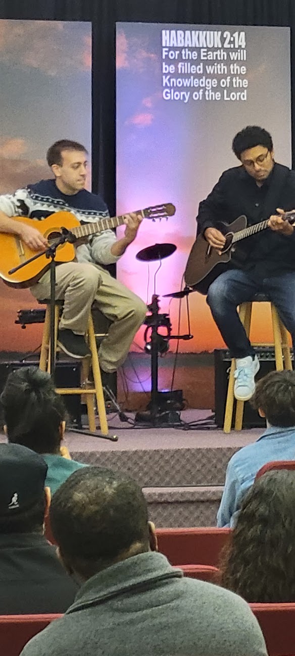 Two young men playing guitar on stage