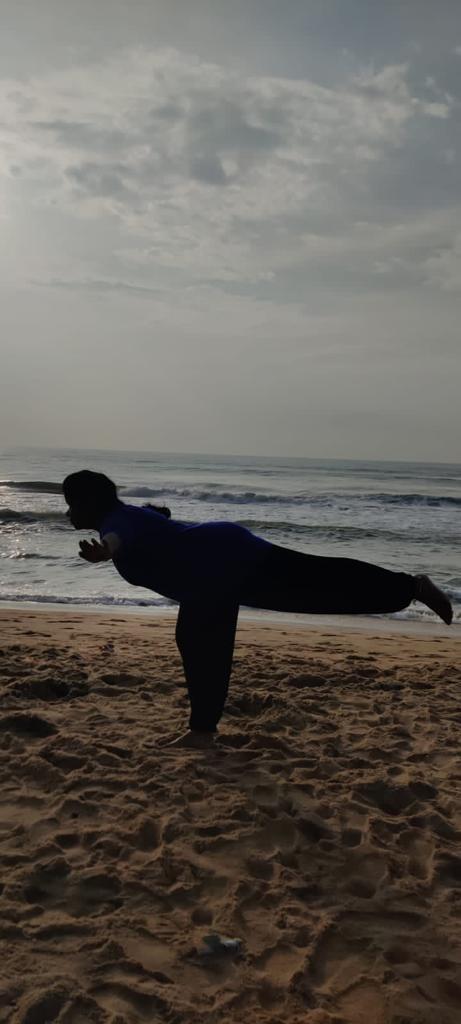 a person doing yoga on a beach