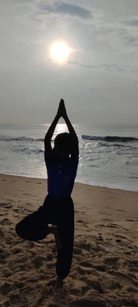 a person doing yoga on a beach