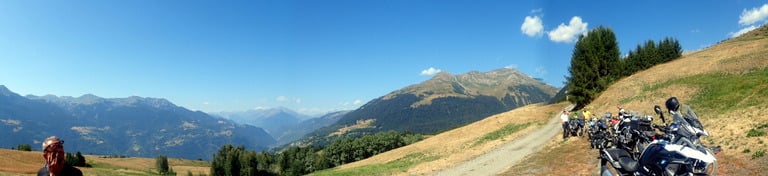 a person standing on a dirt road with a motorcycle