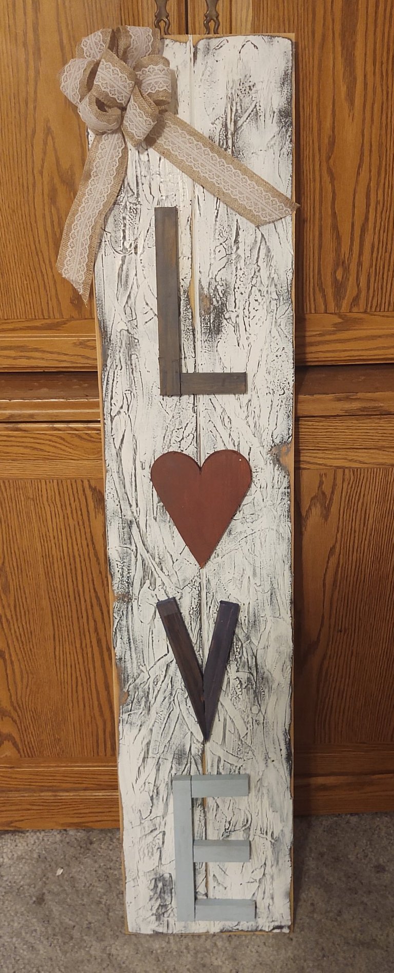 Rustic vertical LOVE wooden sign with a white distressed finish, red heart, and burlap bow.