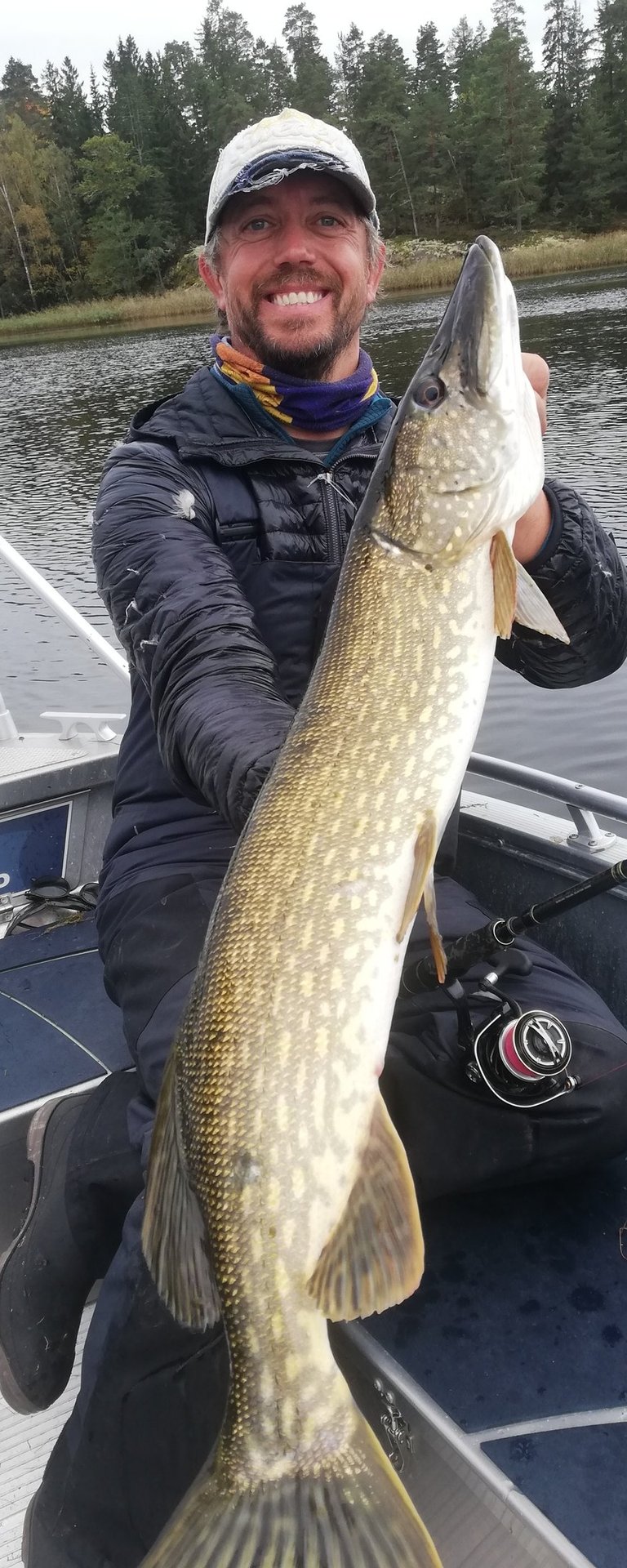 En fiskare håller i en gädda.