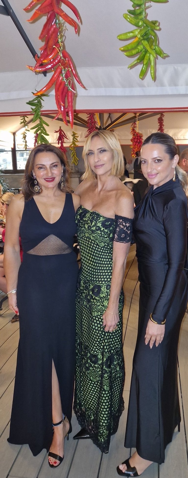 Mary Tornariti at a Rome evening event in a green lace gown with friends.