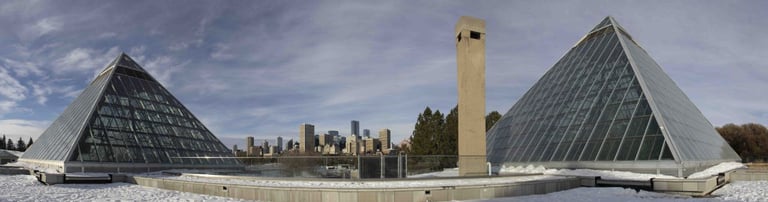 a pyramid shaped building with a clock tower in the background