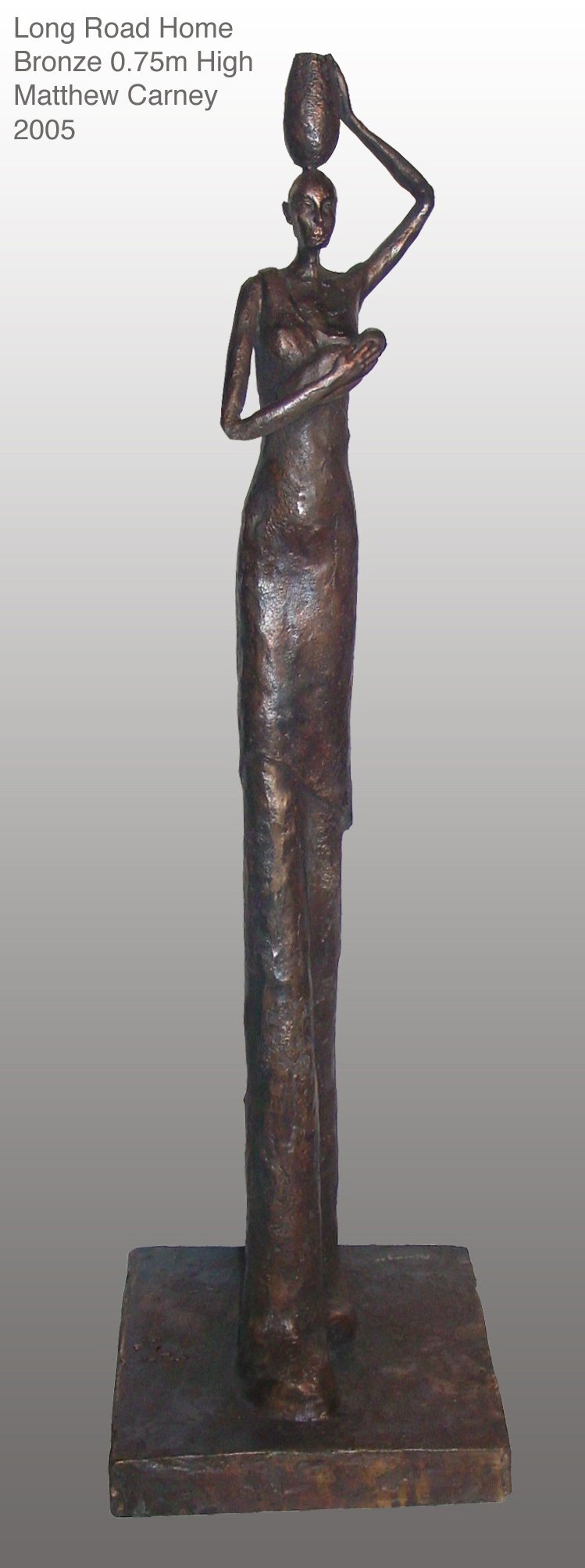 an  elongated sculpture of a woman holding a baby to her breast with a jar of water on her head 