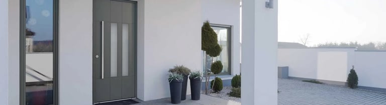 Façade de maison moderne avec porte d'entrée bois aluminium installée par LB Menuiserie