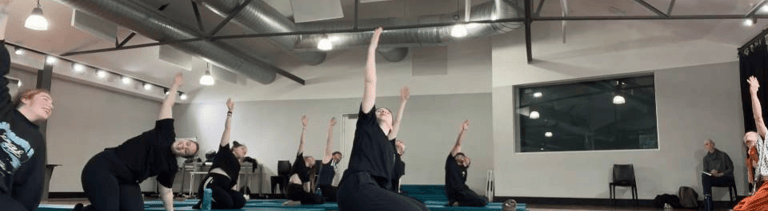 a group of people doing yoga exercises on a wooden floor