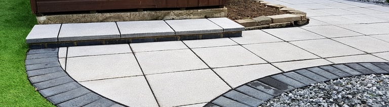 Patio with custom stone circle with aggregates and paving weaving through adventurous garden design