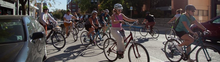Group of women on bikes riding on a downtown street