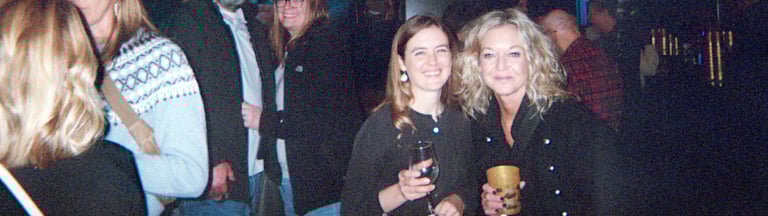 People posing with their drinks in a crowd