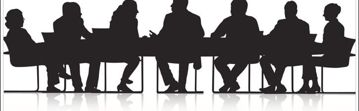 Silouhettes of people sitting at a conference table