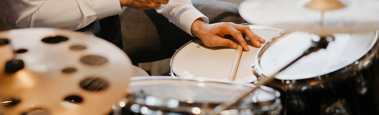a man in a tie and tie shirt playing drums