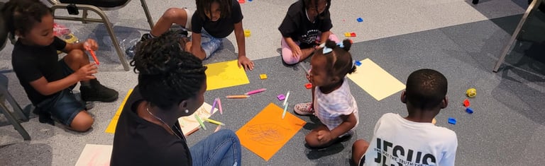 a group of children sitting on the floor in a circle drawing