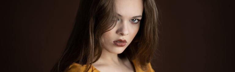 Professionelles Portrait einer jungen Frau mit braunem Haar vor dunklem Hintergrund in Chur
