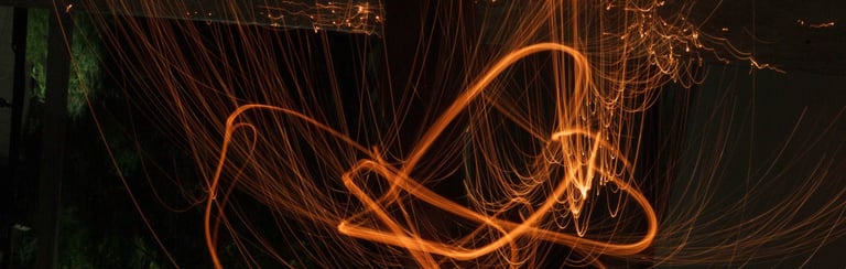 Long exposure light painting glowing orange fire trails and sparks at night delightful Impressions