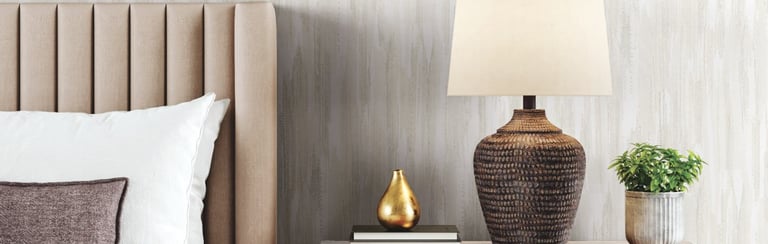 Modern bedroom with a channel-tufted headboard, wooden nightstand, and textured wallpaper background.