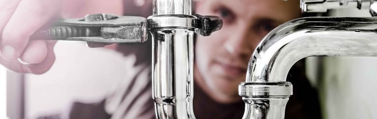 Un plombier ressert un siphon de lavabo