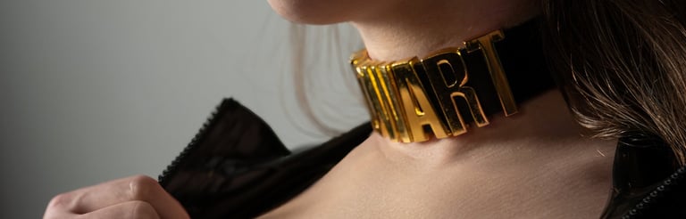 Frau trägt goldenen Statement-Halsschmuck mit Schriftzug, professionelle Portraitfotografie