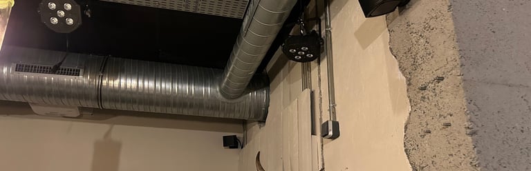 Plafond industriel avec conduits CVC exposés, éclairage de scène et décoration murale de crâne de t