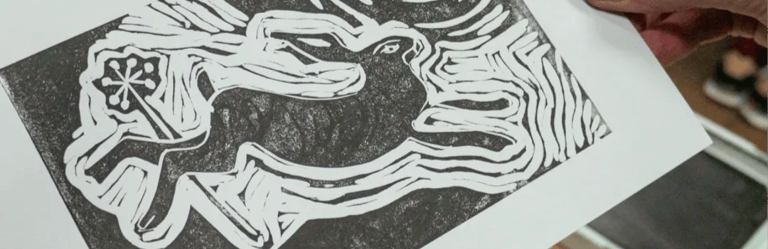 A handmade black and white linocut print of a running hare under a full moon.