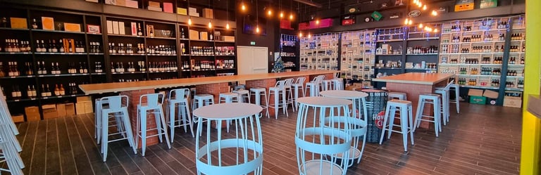 Intérieur de boutique de vin moderne et de bar à bière artisanale avec tabourets en métal blanc