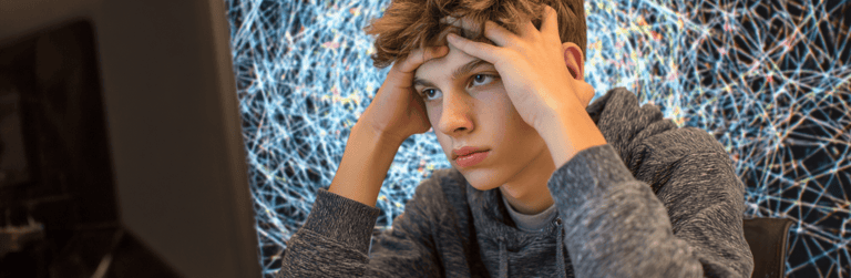 a young man sitting at a computer desk