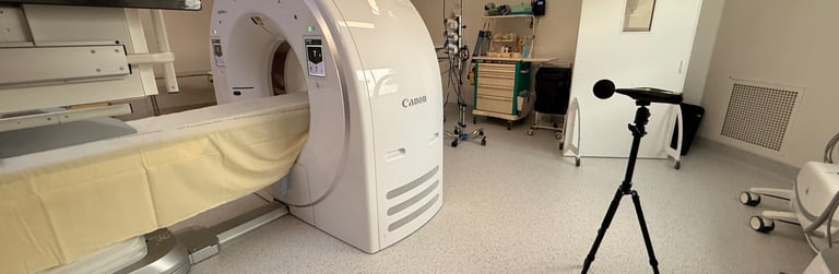 Un scanner CT Canon moderne dans une salle d'imagerie médicale lumineuse avec un sonomètre trépied.