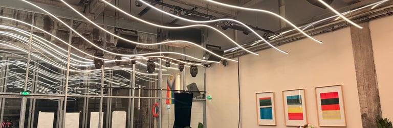 Intérieur de café industriel moderne avec plafonniers à bande LED incurvés et tables en bois