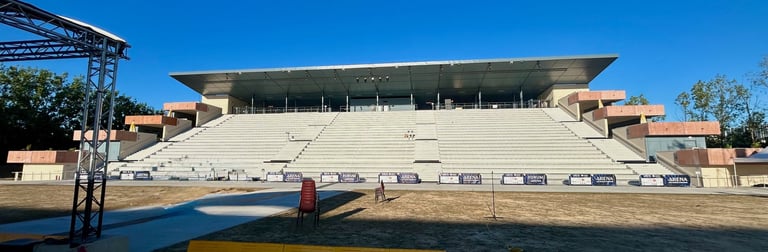 Stade d'amphithéâtre extérieur vide avec des sièges en béton à plusieurs niveaux et un toit en métal