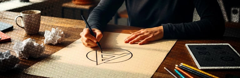 Graphiste en plein travail de création d'identité visuelle et de logo sur papier.