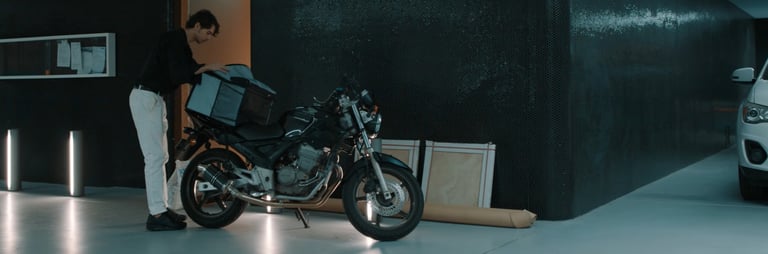 a man standing next to a motorcycle in a garage
