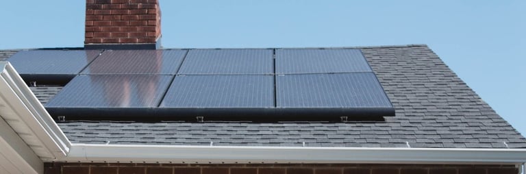 a house with a solar paneled roof and a lawn chair